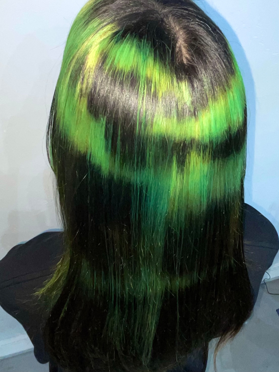 Back view of sleek black hair with vibrant green and yellow highlights, styled for Rebecca Sauvé by Taiga Sato, showcasing a bold, artistic look.