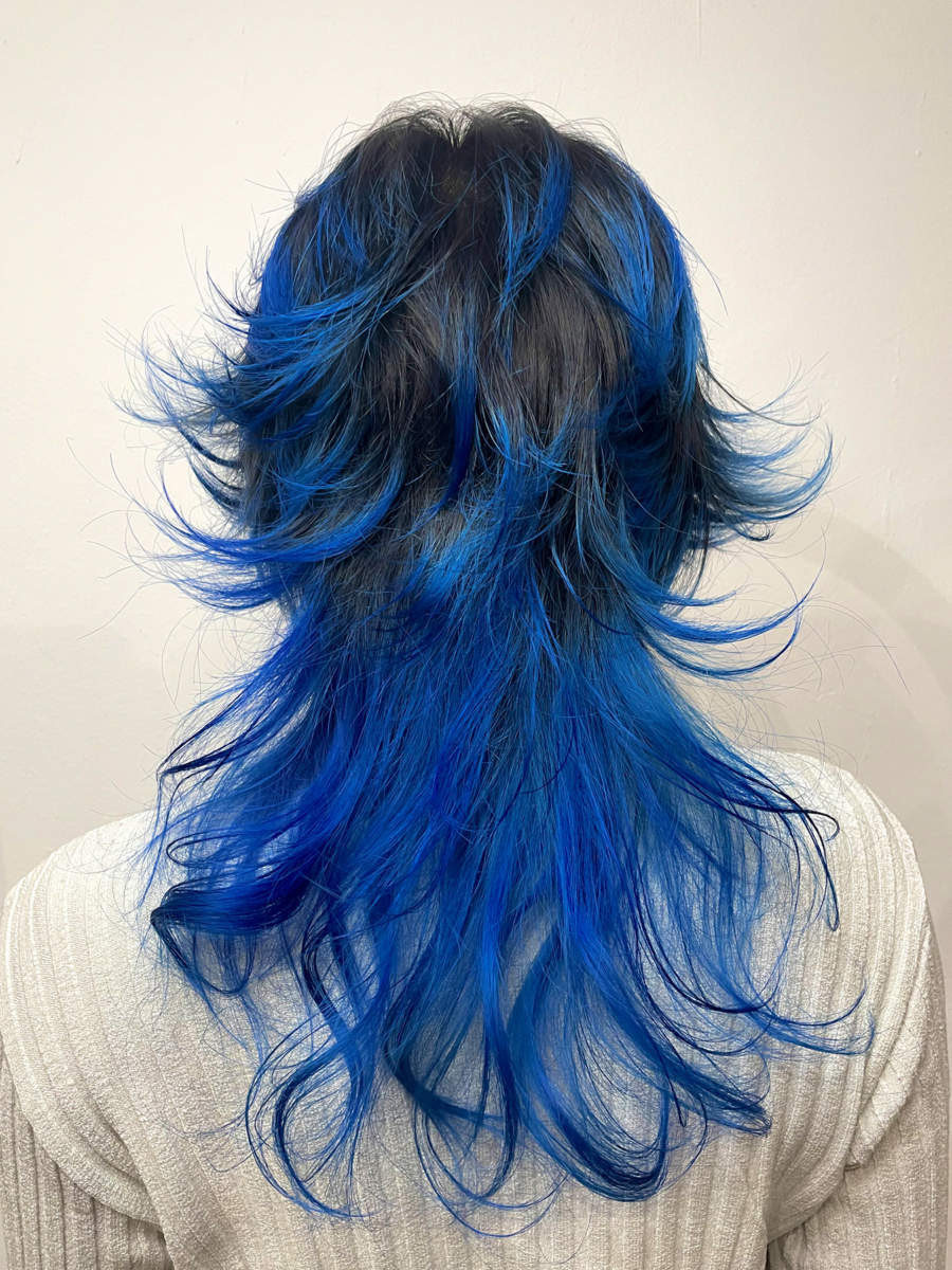 Bright blue layered hairstyle created for Jasmin Halama, showcasing vivid tones and airy texture.