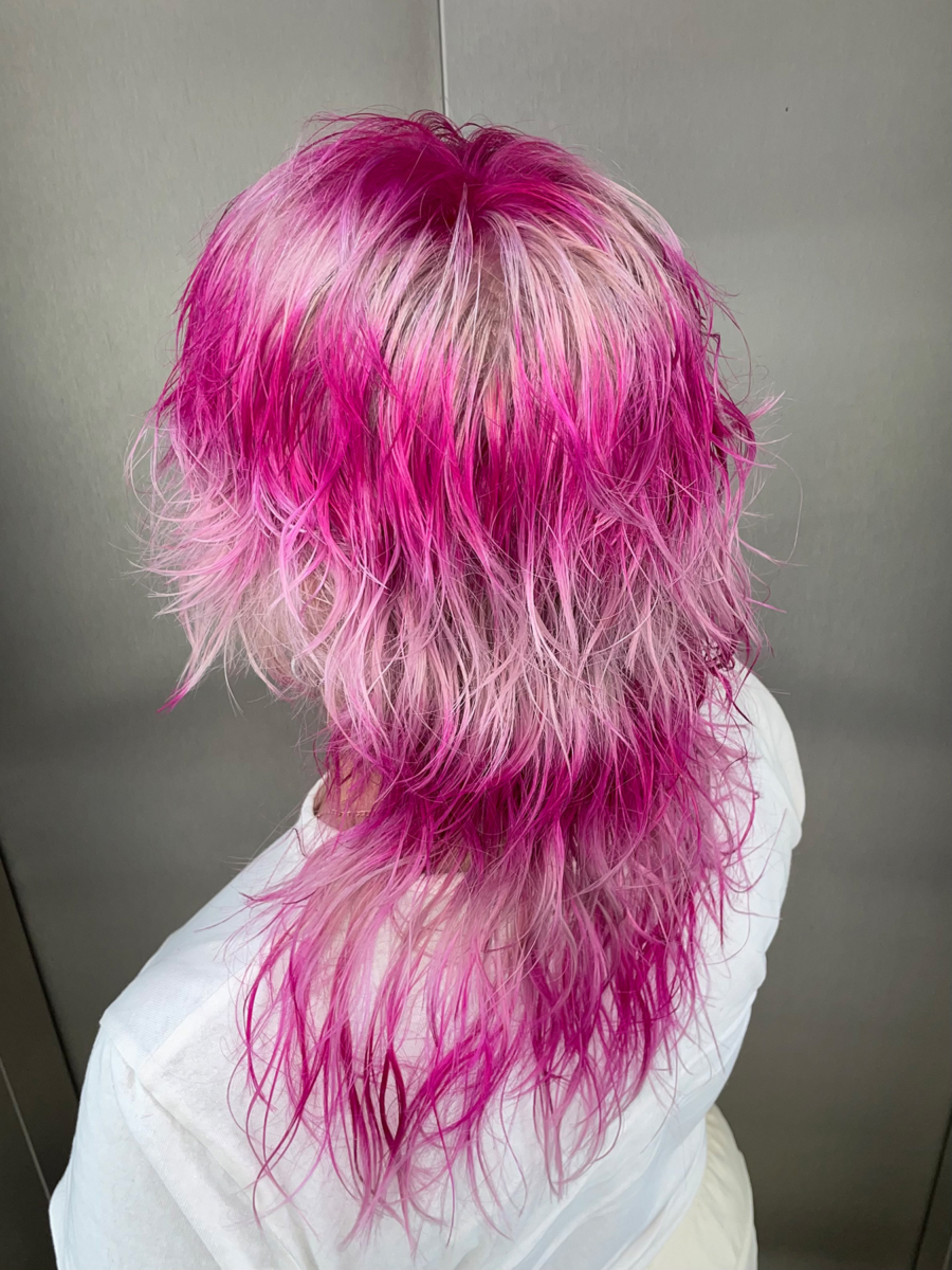 Vibrant pink and light pastel hair in a shaggy mullet style, featuring a gradient blend from hot pink roots to soft pastel tips. Haircut for Angie Lora (@doodlesbyangie), showcasing a bold and artistic hair design.