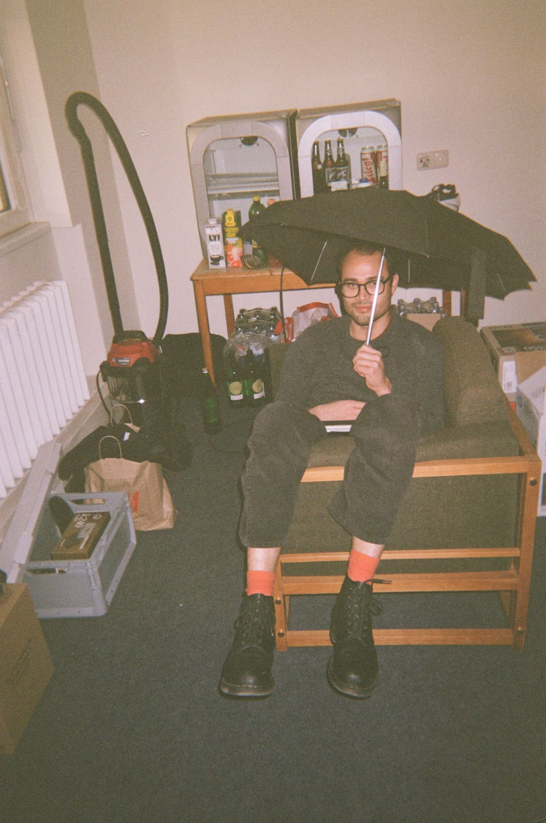 Mitglied sitzend mit Regenschirm